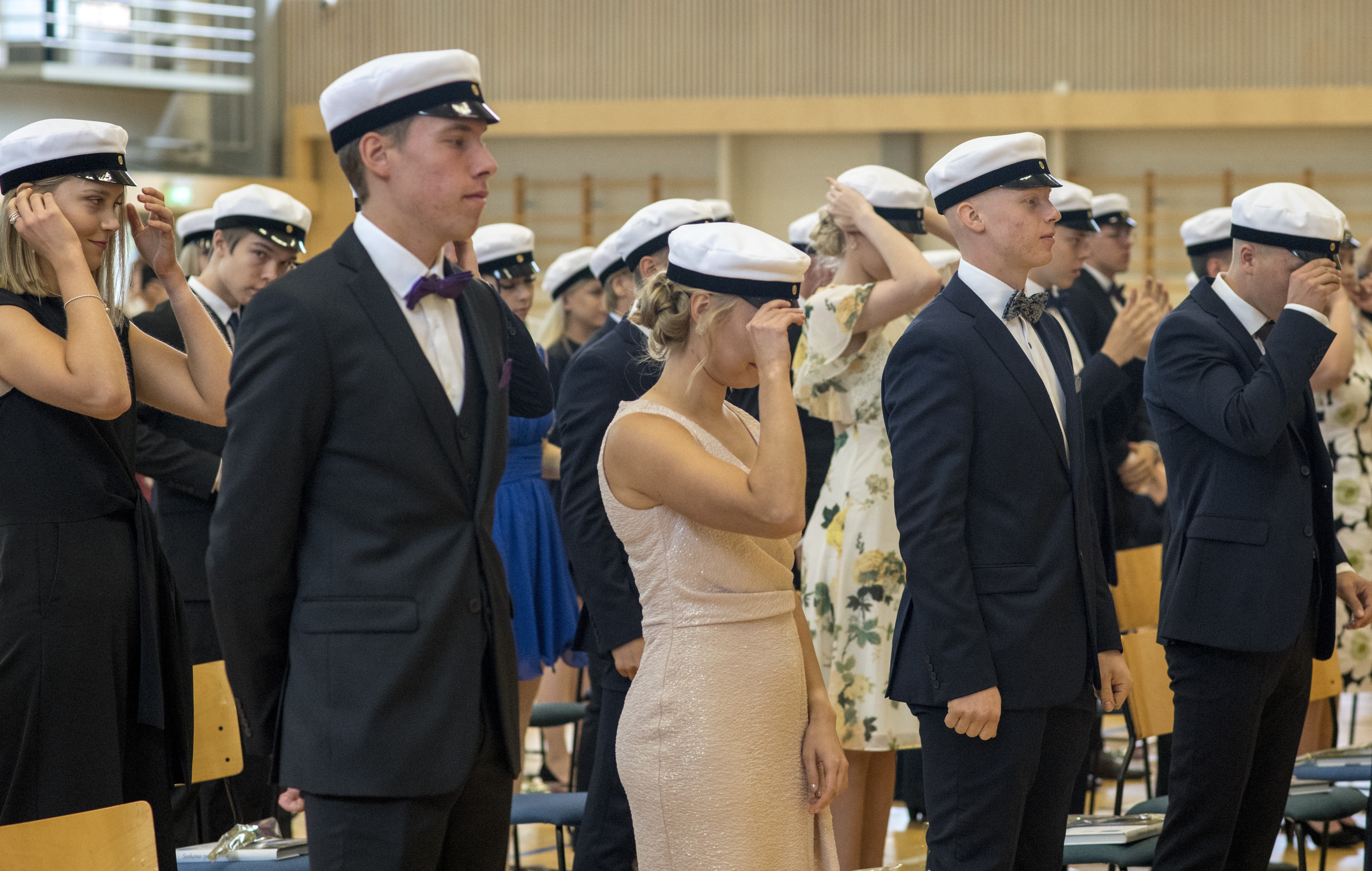 Ylioppilaat lakit päässä